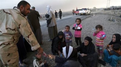 People rest as they flee their homes during clashes between Iraqi security forces and ISIL in Mosul, Iraq [AP]