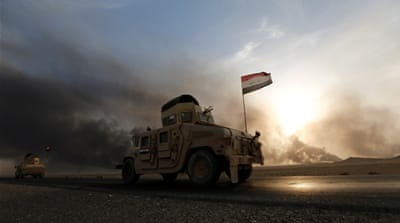 Iraqi army gathers after the liberation of a village from ISIL, south of Mosul [Reuters]