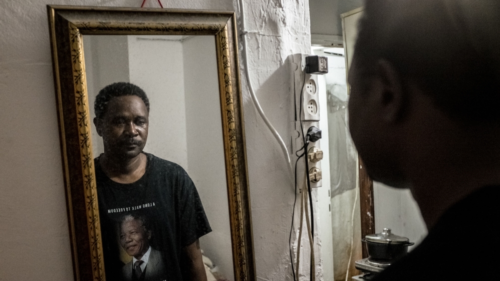 Walyaldin Suliman shares a rented room with another asylum seeker in southern Tel Aviv, Israel [Violeta Moura/Al Jazeera]