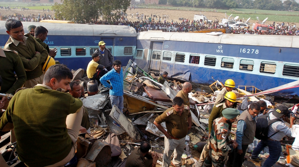 Rescue workers search for survivors at the site of a train derailment in Pukhrayan, south of Kanpur city [Jitendra Prakash/Reuters]