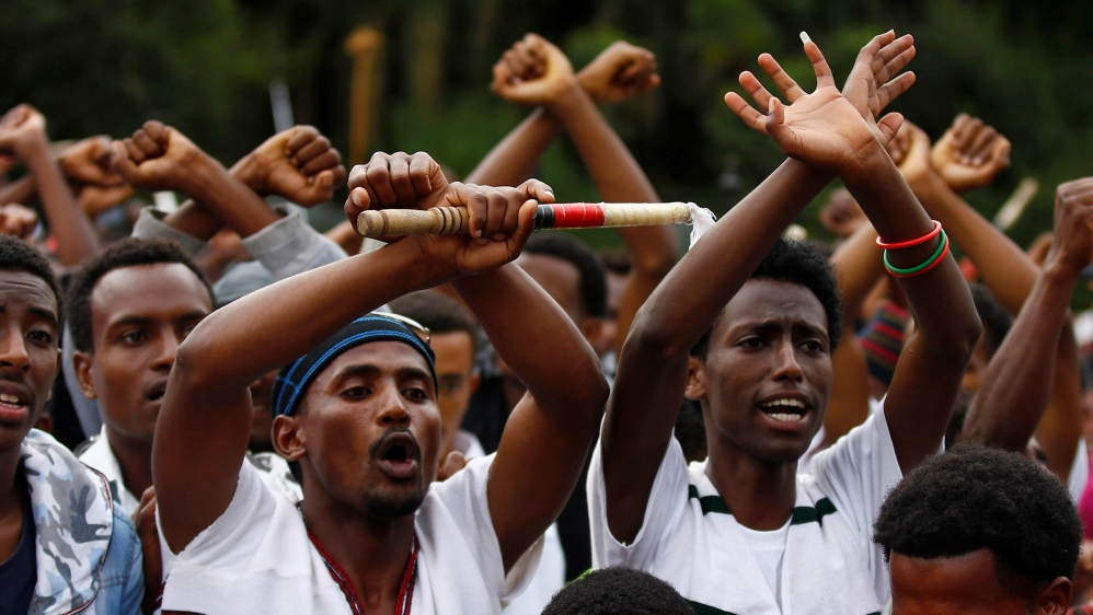 Demonstrators chant slogans while flashing the Oromo protest gesture during Irreecha, the thanksgiving festival of the Oromo people, in Bishoftu town, Oromia region, Ethiopia