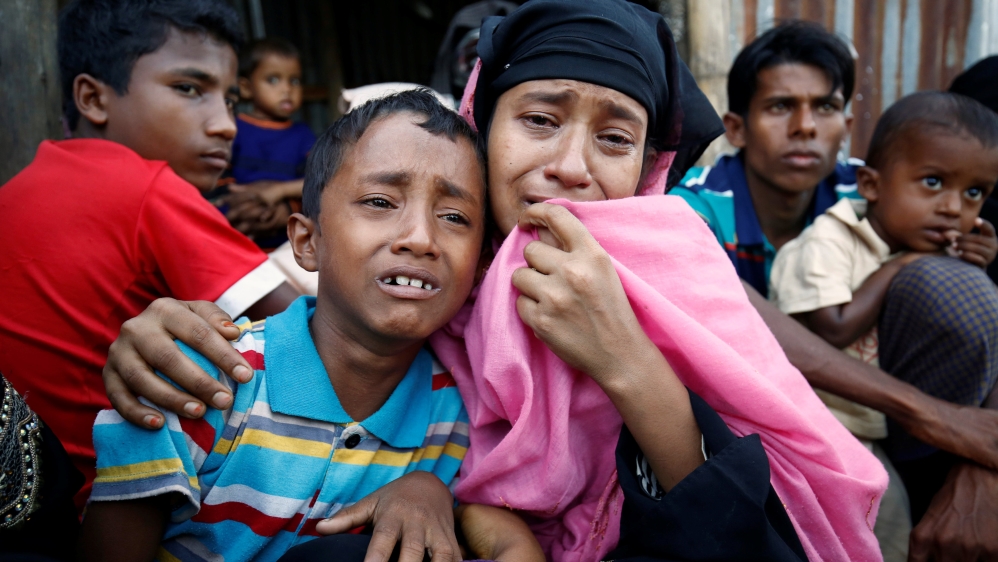 A Rohingya Muslim woman and her son cry after being caught by Border Guard Bangladesh while illegally crossing at a border check point in Cox’s Bazar