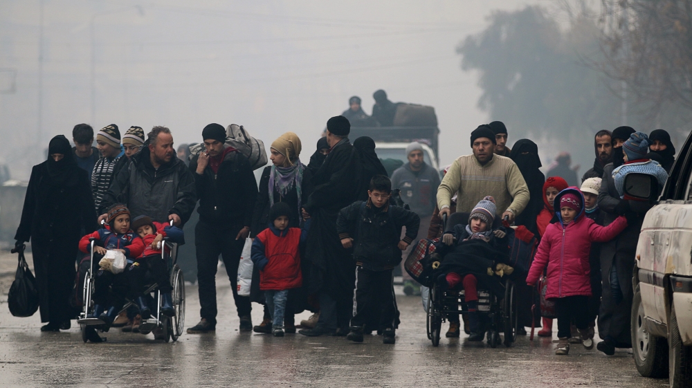 People walk as they flee deeper into the remaining rebel-held areas of Aleppo