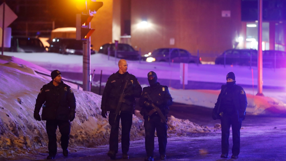 Police officers patrol the perimeter near a mosque after a shooting in Quebec City