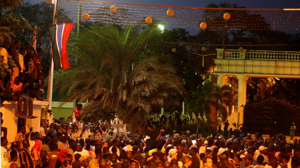 Banjul residents gathered in front of the State House to watch ECOWAS forces secure the compound [Thierry Gouegnon/Reuters]
