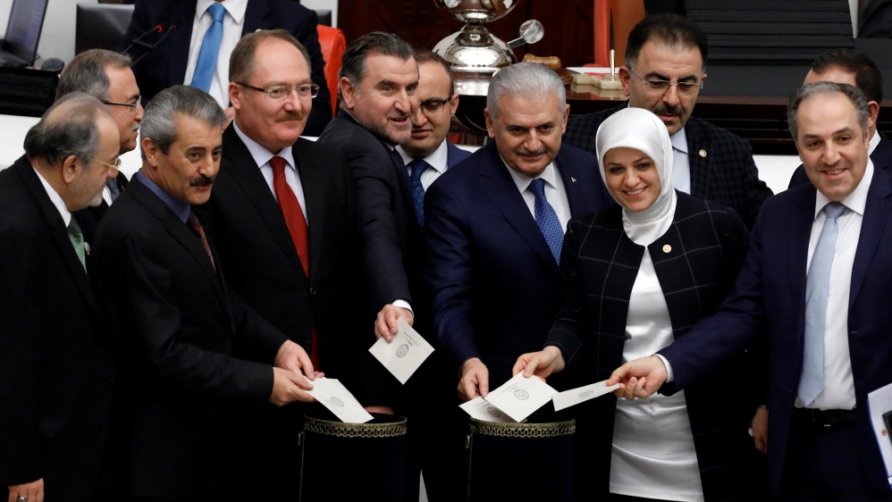 Turkish Prime Minister Binali Yildirim poses with MPs as he votes during a debate on the proposed constitutional changes at the Turkish Parliament in Ankara