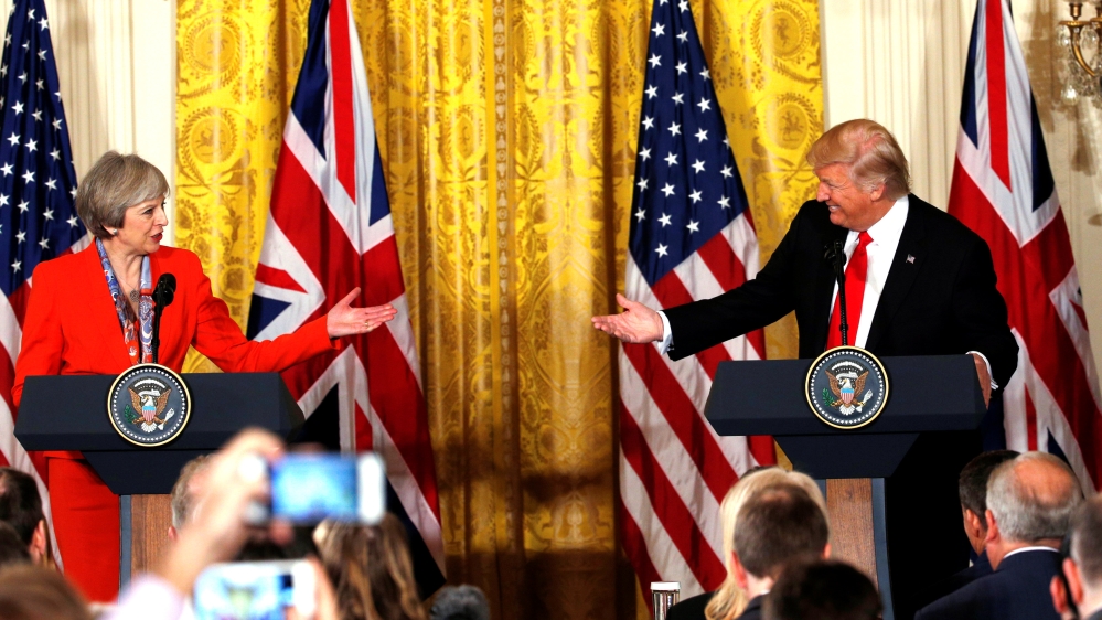 British Prime Minister May and U.S. President Trump gesture towards each other as they hold a joint news conference at the White House in Washington