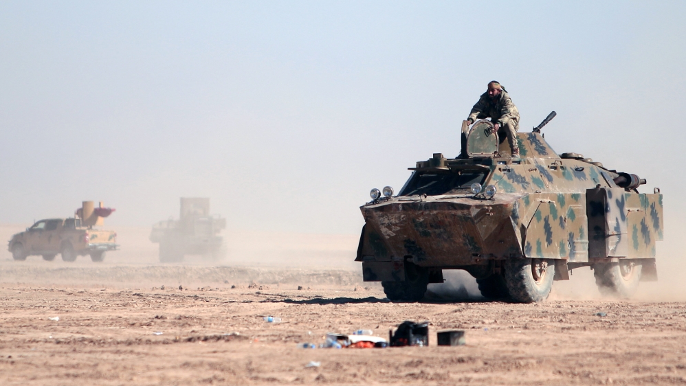 A Syrian Democratic Forces (SDF) fighters sits on a vehicle in the north of Raqqa city