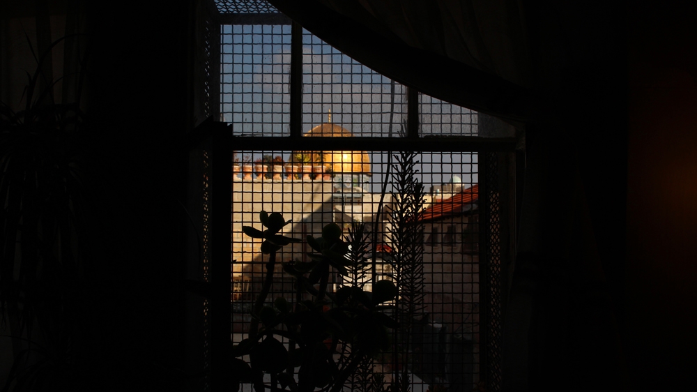 A window in the Sub Laban family's home frames the iconic Dome of the Rock in Al-Aqsa Mosque compound [Jaclynn Ashly/Al Jazeera]