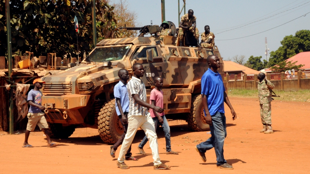 Members of the South Sudan''s National Security Services guard as civilians walk to an address where South Sudan''s Vice-President Taban Deng Gai addresses the audience, at the the Freedom Square in Yei