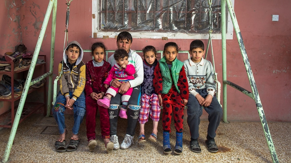  Seif Zaidan Khalaf sits with some of the children of his brother and cousin, who were killed in an air strike last November [Joao Castellano/Al Jazeera]