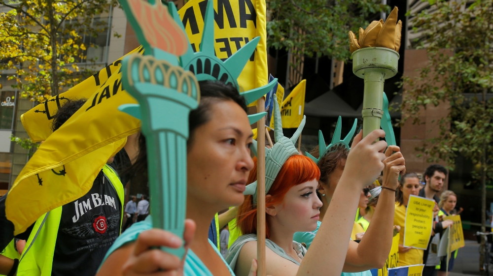 Protesters wearing Statue of Liberty outfits rally against the travel ban in Sydney, Australia [Jason Reed/Reuters]