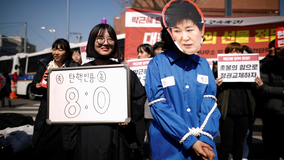 People celebrate after hearing that President Park Geun-hye''s impeachment was accepted, near the Presidential Blue House in Seoul