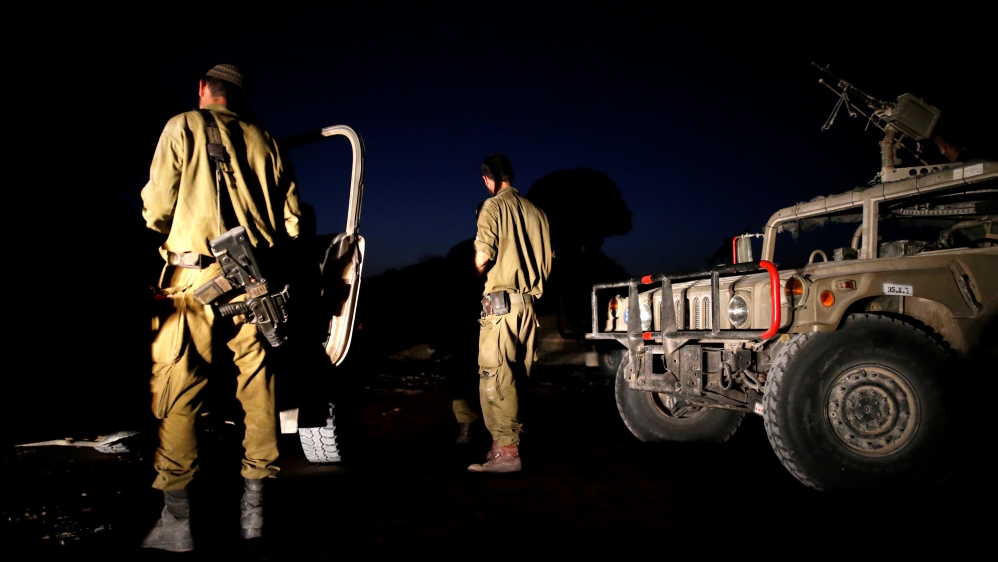 Israeli soldiers are seen just outside the Israeli-Gaza border near kibbutz Nir Am