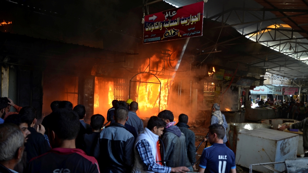 Shops in flames after mortar shells landed in a market in Mosul on Sunday [Reuters] 