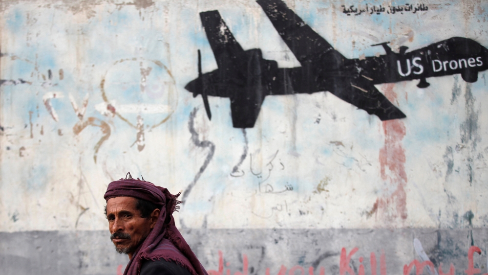 Man walks past a graffiti, denouncing strikes by US drones in Yemen, painted on a wall in Sanaa, Yemen [File: Khaled Abdullah/Reuters]