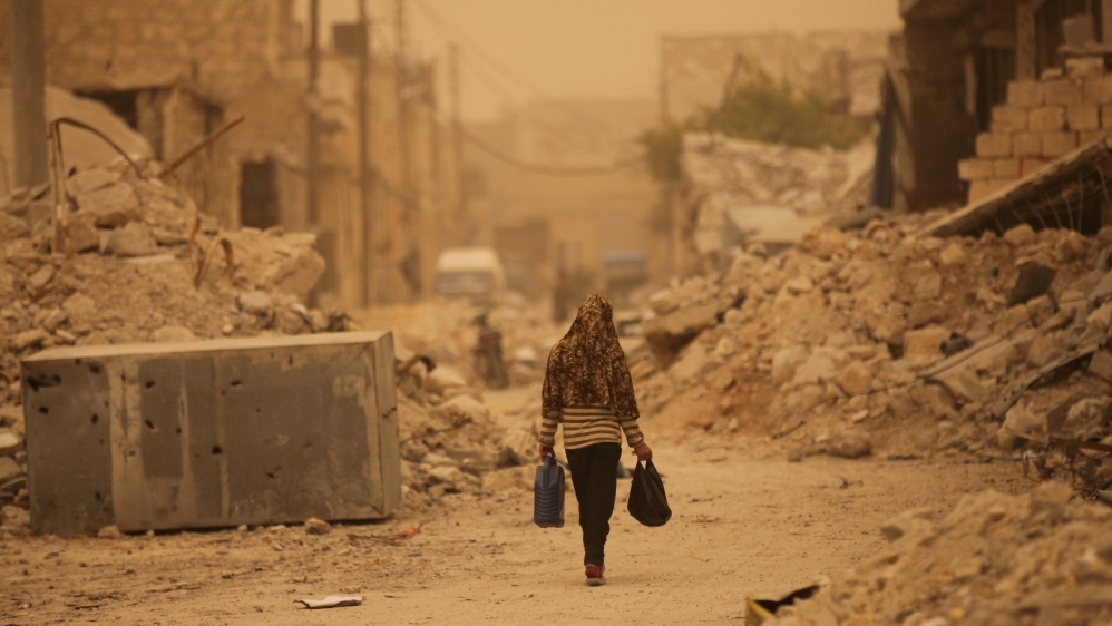 A civilian walks along a street during a dust storm in the northern Syrian town of al-Bab