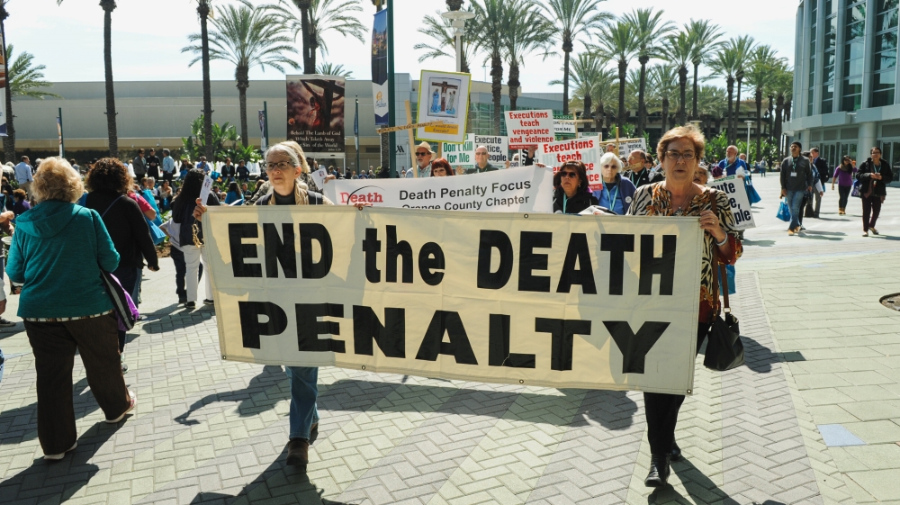 Demonstrators march through a courtyard during a rally protesting against the death penalty and in favor of immigration reform in Anaheim, California