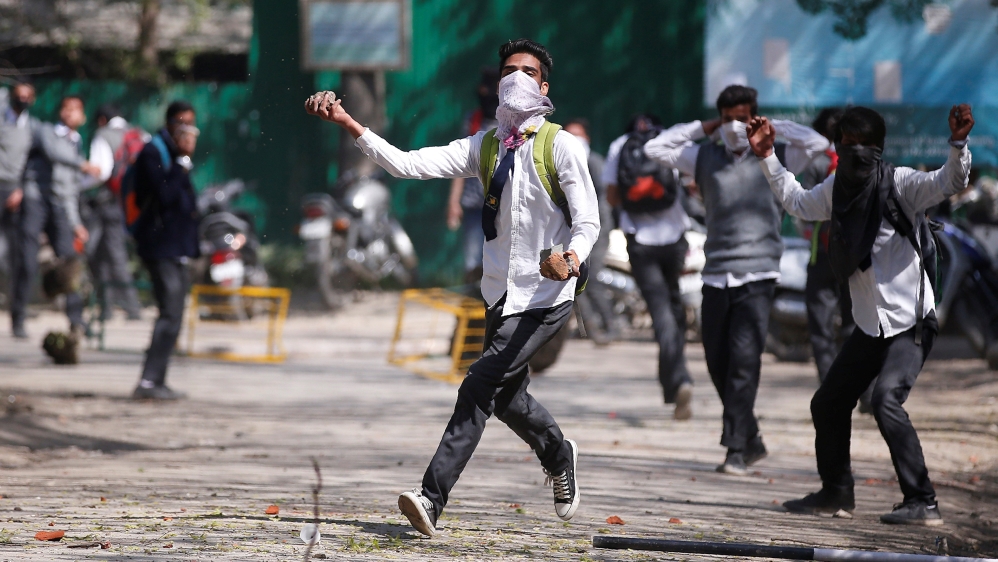 A Kashmiri student throws a piece of stone during a protest in Srinagar