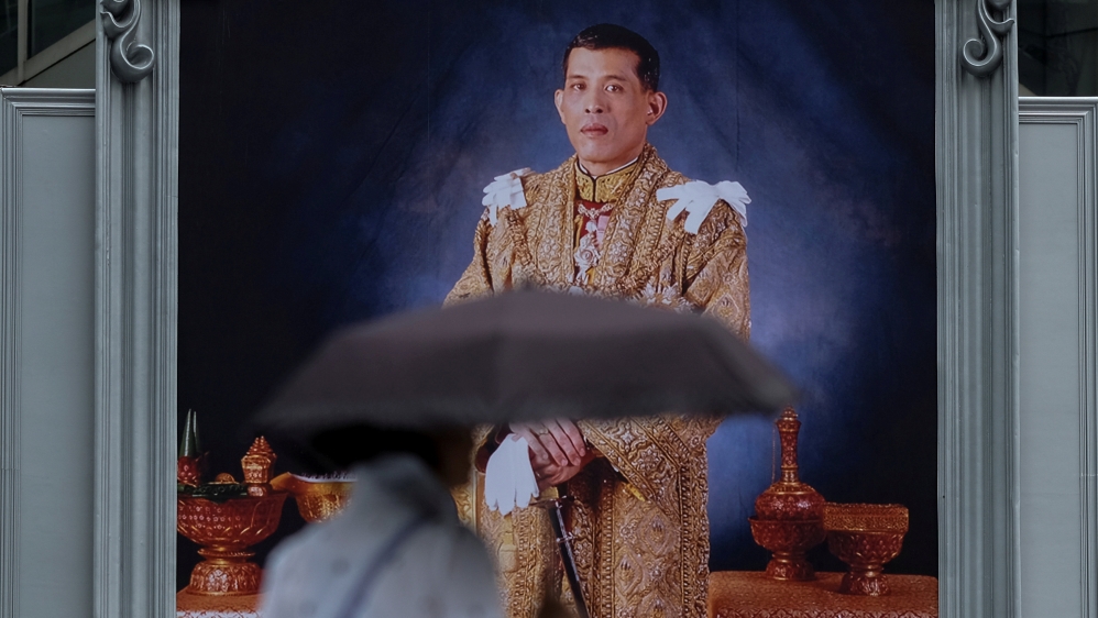 FILE PHOTO - A woman walks past a portrait of Thailand''s King Maha Vajiralongkorn Bodindradebayavarangkun at a department store in central Bangkok