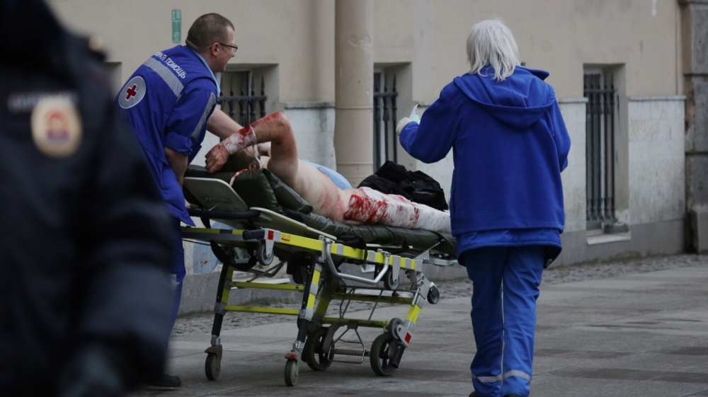 An injured person is helped by emergency services outside Sennaya Ploshchad metro station following explosions in St. Petersburg