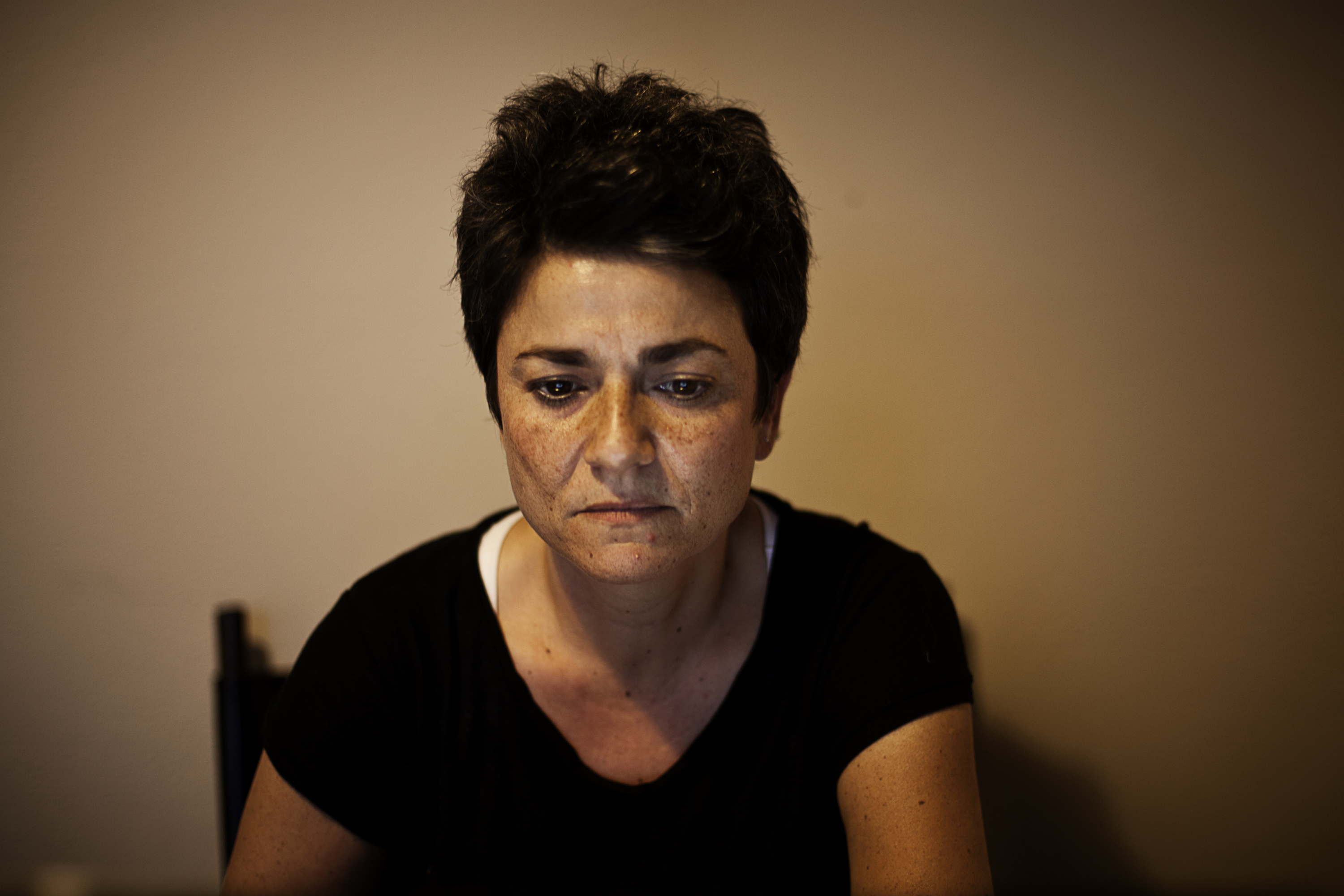 Emmy looks at pictures of her father at her home [Paulo Siqueira/Al Jazeera]