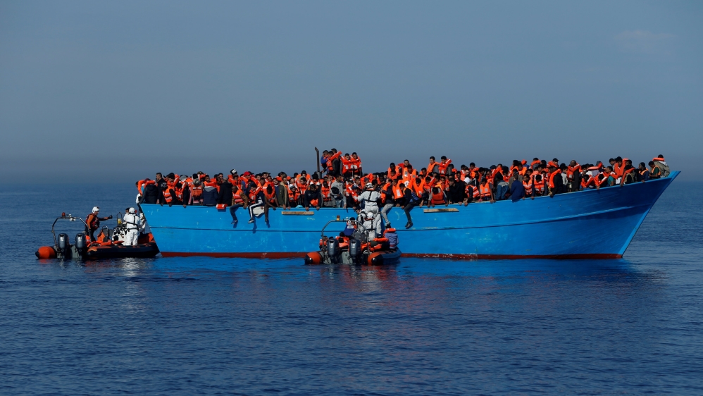 FILE PHOTO: Migrants on a wooden boat are rescued by the Malta-based NGO Migrant Offshore Aid Station (MOAS) in the central Mediterranean