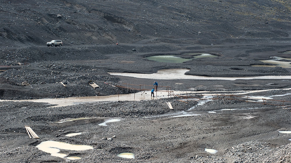 Two guides construct a new bridge across a meltwater river near the Falljokull glacier. As the melt rate changes through the summer months, run-off increases, often changing a river's path [Alexander Lerche/Al Jazeera]