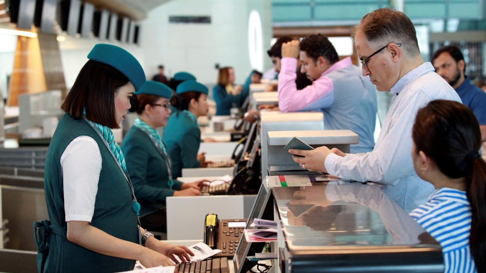 Staff speak with passengers at Hamad International Airport in Doha