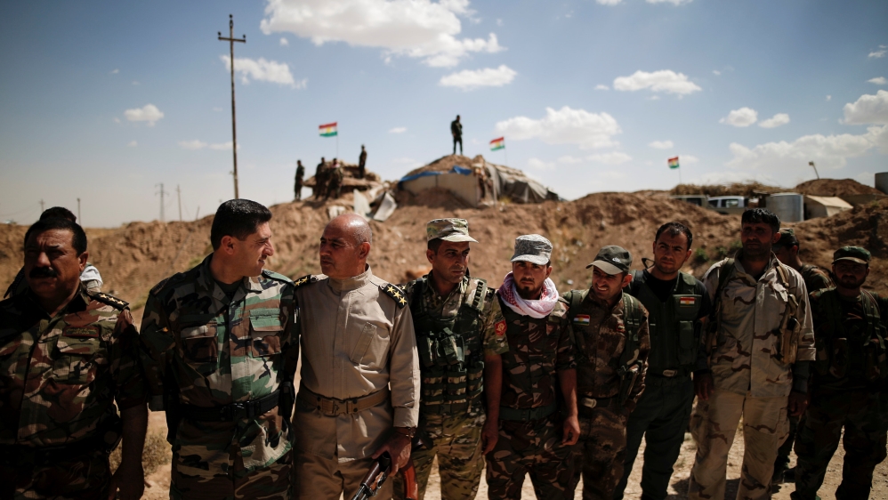 Kurdish Peshmerga fighters line up to welcome Yazidi survivor and United Nations Goodwill Ambassador for the Dignity of Survivors of Human trafficking Nadia Murad at a defensive point near Sinjar
