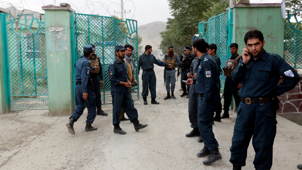 Afghan policemen stand gurad near the site of blasts in Kabul