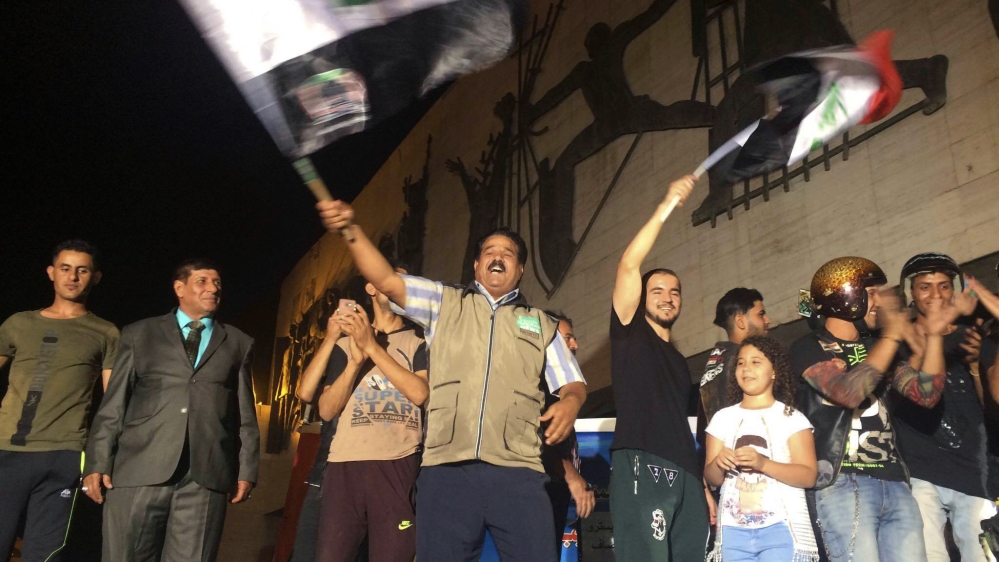 Iraqis celebrate victory over ISIL in Mosul in Baghdad's Tahrir Square [Karim Kadim/AP]