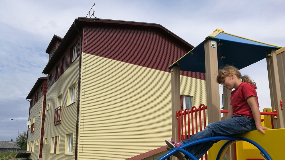A girl plays next to a remodelled slaughterhouse in the northwestern Russian town of Sortavala, where secular residents of the nearby island of Valaam were offered apartments. The house has no central heating and its walls are covered with toxic fungi and mould, an independent investigation concluded [Mansur Mirovalev/Al Jazeera]