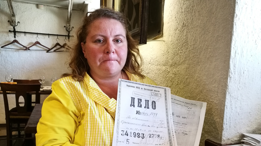 Varvara Sergeeva shows a copy of the 1937 investigation and court papers detailing a death sentence handed down to her great-grandfather, Pavel Orleansky, a deacon at the Valaam Monastery in northwestern Russia. Eighty years after his execution, the monastery forced Sergeeva and her son off the island [Mansur Mirovalev/Al Jazeera]