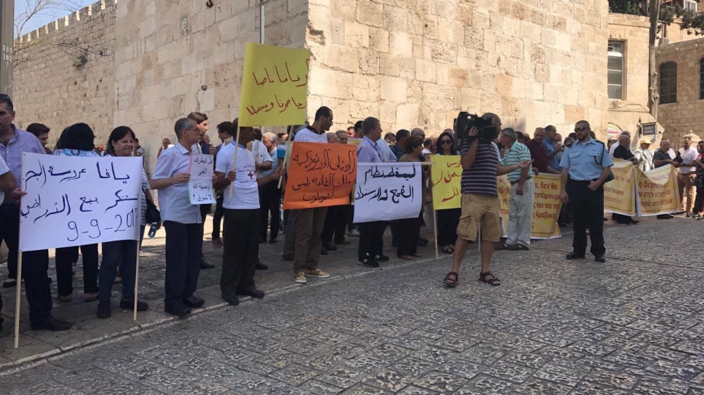 Signs read: 'The Orthodox endowments are for the sect and not for Theophilos' and 'Our endowments are our past, future and present' [Al Jazeera]