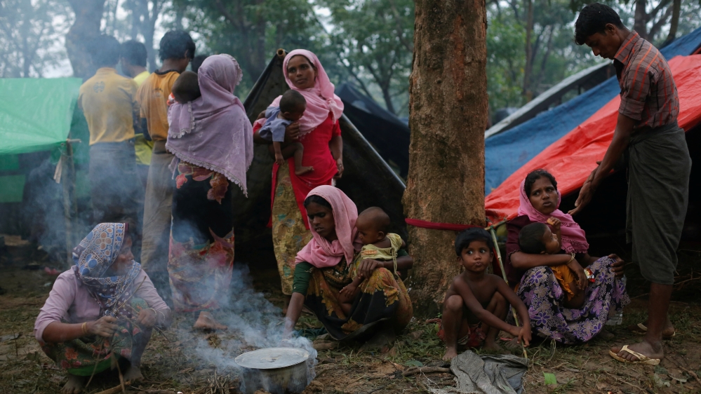 Rohingya refugees go about their day outside their temporary shelters along a road in Kutupalong, Bangladesh