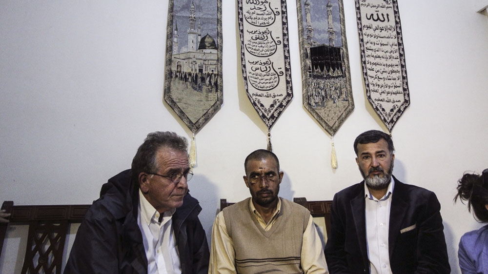 Migration Minister Yiannis Mouzalas, left, meets with Ashfak Mahmoud, centre, and Javed Aslam after the attack [Nikos Libertas/SOOC/Al Jazeera]