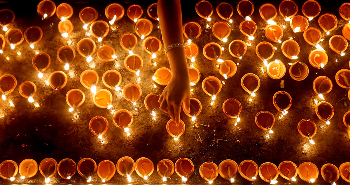 A devotee lights oil lamps at a religious ceremony during the Diwali or Deepavali festival at a Hindu temple in Colombo, Sri Lanka October 18, 2017. REUTERS/Dinuka Liyanawatte TPX IMAGES OF THE DAYA d