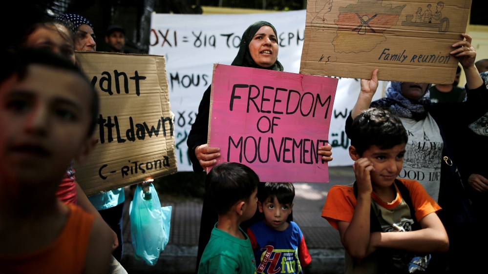 A Syrian refugee holds banner during a demonstration against delays in reunifications of refugee families from Greece to Germany, in Athens