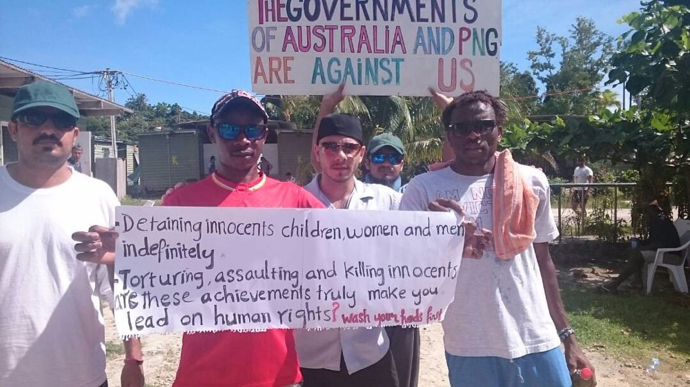 Refugees hold up signs to protest against their treatment by the Australian and PNG governments [Courtesy @ManusAlert Telegram]