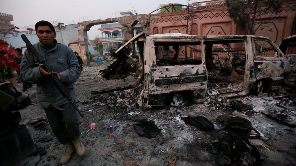 An Afghan policeman inspects the site of a blast in Jalalabad