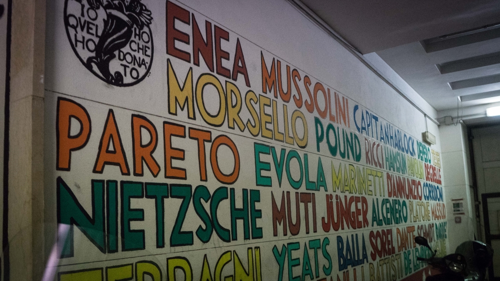 The wall inside CasaPound's squat is covered in the names of politicians, authors and philosophers [Patrick Strickland/Al Jazeera]
