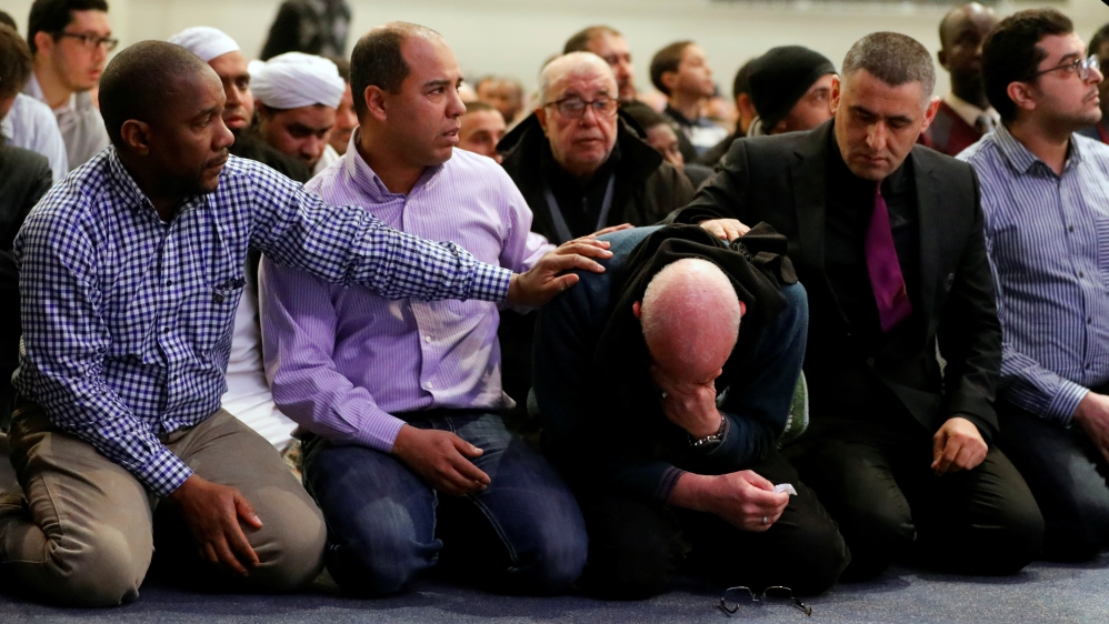 A man is comforted as he cries during a funeral ceremony for three of the victims of the deadly shooting of the Quebec Islamic Cultural Centre at the Congress Center in Quebec City