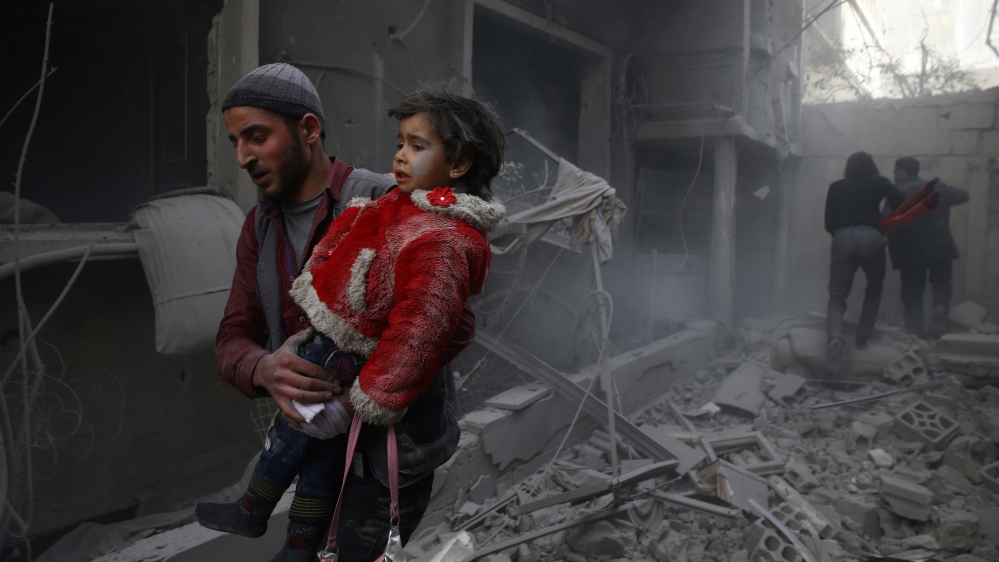Man holds child after airstrike in besieged town of Douma, Eastern Ghouta, Damascus