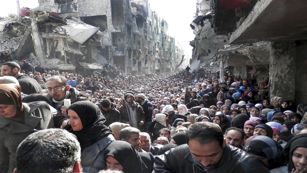Residents in Yarmouk line up to receive food supplies in 2014 [AP/UNRWA]