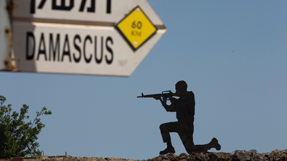 A mock road sign for Damascus, the capital of Syria, and a cutout of a soldier, are displayed in an old outpost in the Israeli controlled Golan Heights near the border with Syria, Thursday, May 10, 20