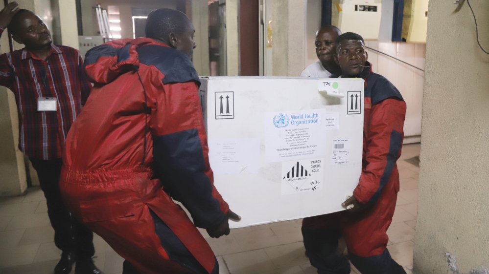 Congolese Health Ministry officials carry the first batch of experimental Ebola vaccines in Kinshasa