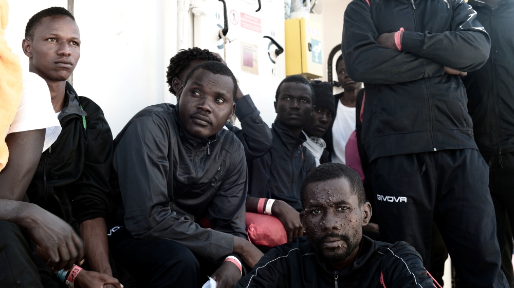 Migrants wait to disembark from the Aquarius rescue ship after arriving to port in Valencia