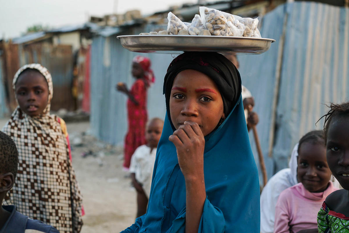 A young girl inside Buzu Quarters Camp, an informal host community in Maiduguri with shelters built by a local Nigerian to house IDPs.
