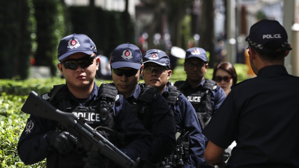 Police officers patrol outside the St Regis Hotel in Singapore, where Kim is staying. Hosting the summit will reportedly cost the city-state 20m Singapore dollars ($15m), half of which would go to enhancing security [Yong Teck Lim/The Associated Press]